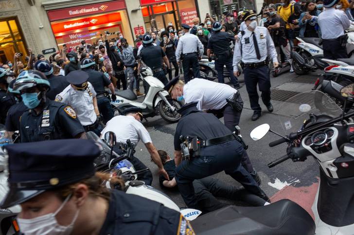 A swarm of NYPD officers arrest a protester on May 28.